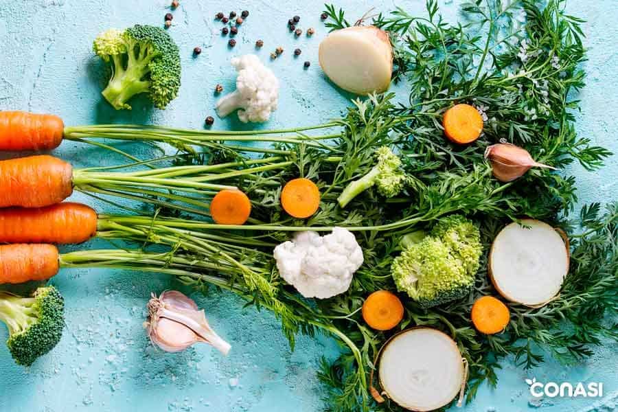 Diferentes verduras sobre un fondo azul - Salud cardiovascular y alimentación vegetal