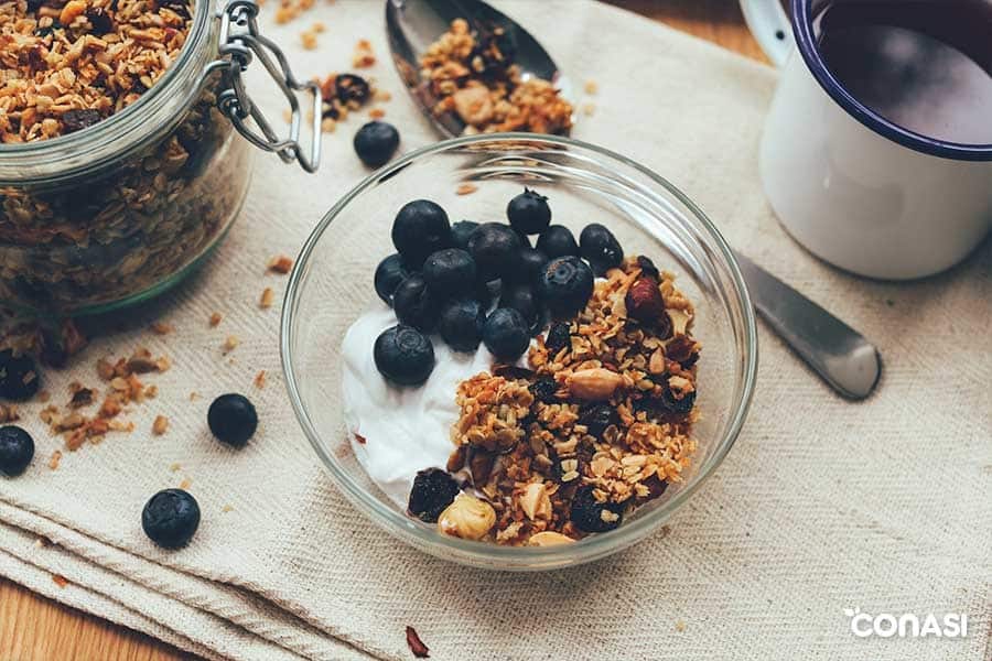 Copos de avena en un bol con yogur y arándanos