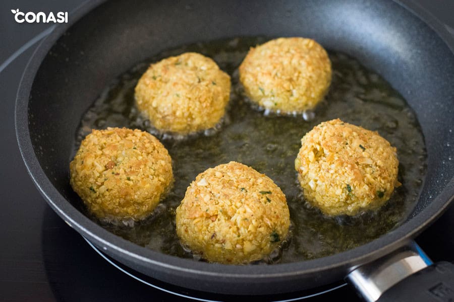 Croquetas vegetarianas redondas en una sartén skk con aceite de oliva.