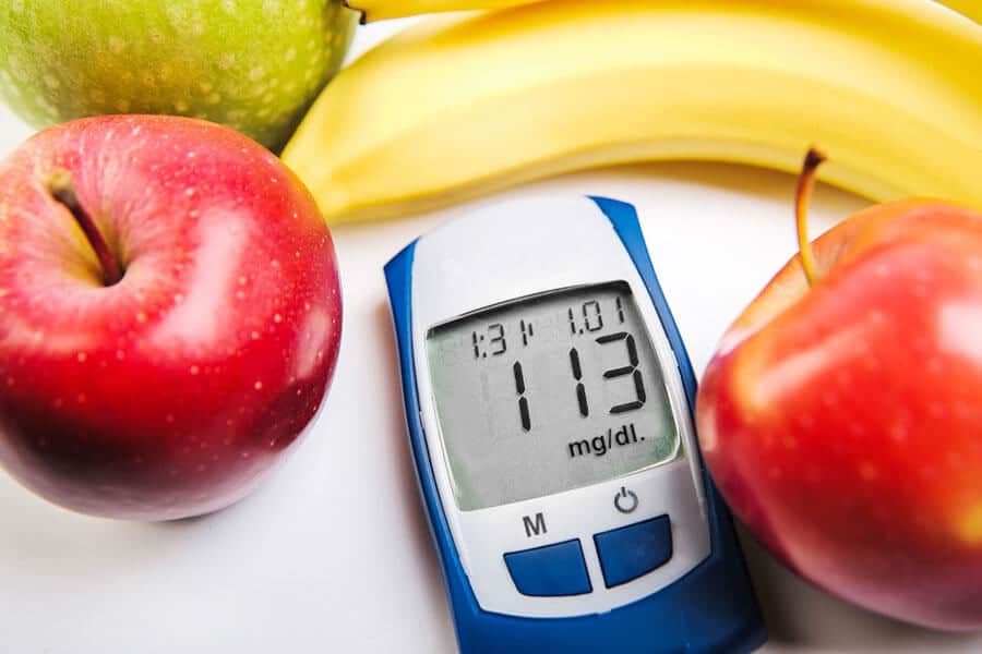 Inflamación crónica - medidor de glucosa junto a piezas de fruta