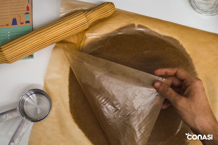 Masa de la quiche paleo entre dos papeles de hornear Masa de la quiche paleo entre dos papeles de hornear