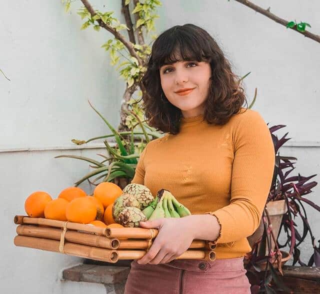 Julia Gómez sosteniendo una bandeja de fruta - Síndrome de Ovario Poliquístico