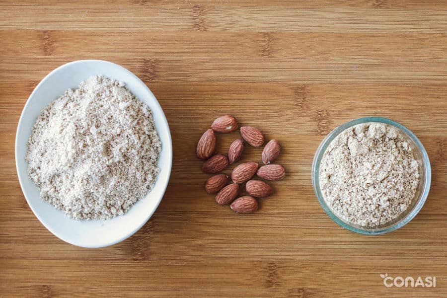 Harina de almendras en cunecos y almendras en la mesa